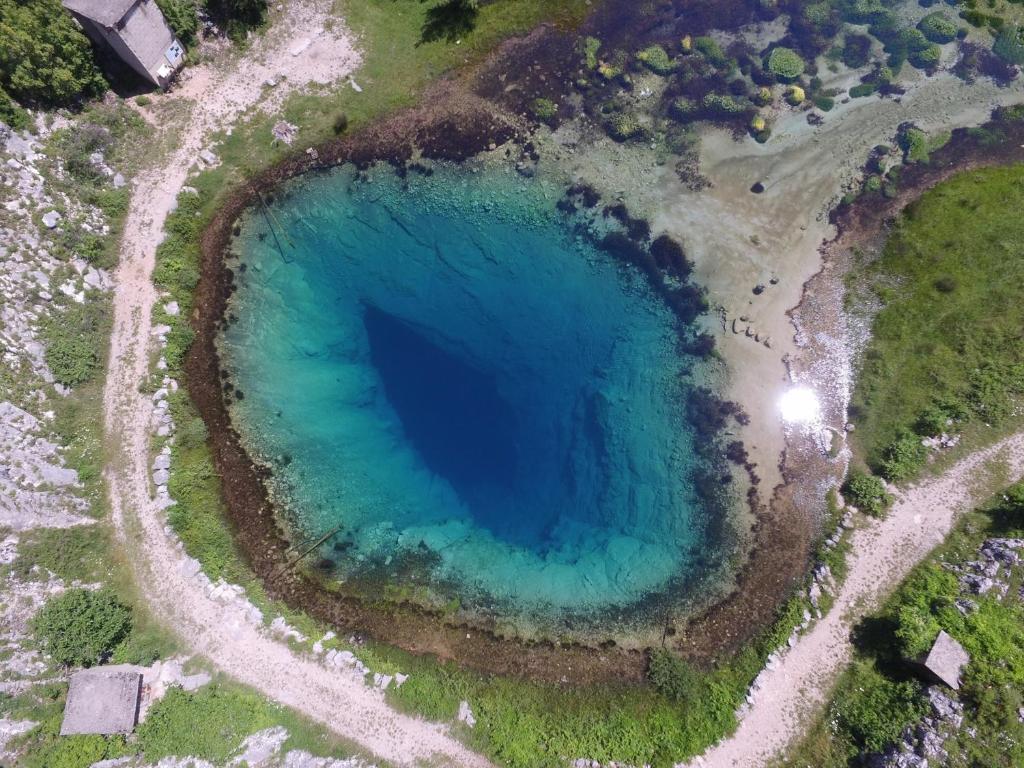 an aerial view of a large blue lake at Villa Cetina in Milaši