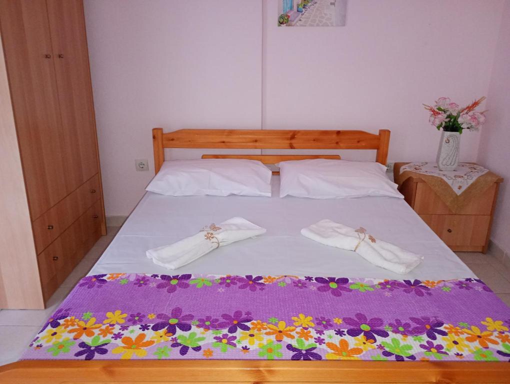 a bed with two white shoes on top of it at Katerina Apartments in Flogita