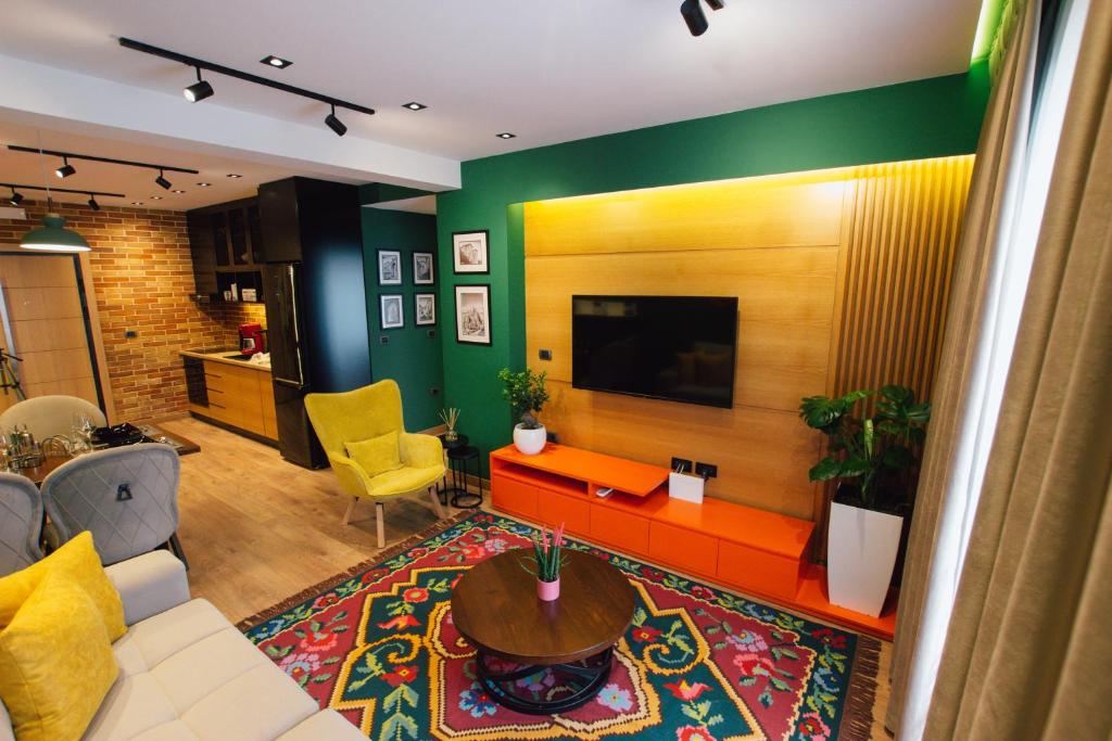 a living room with a couch and a tv at Brilant Luxury Apartment in Gjirokastër