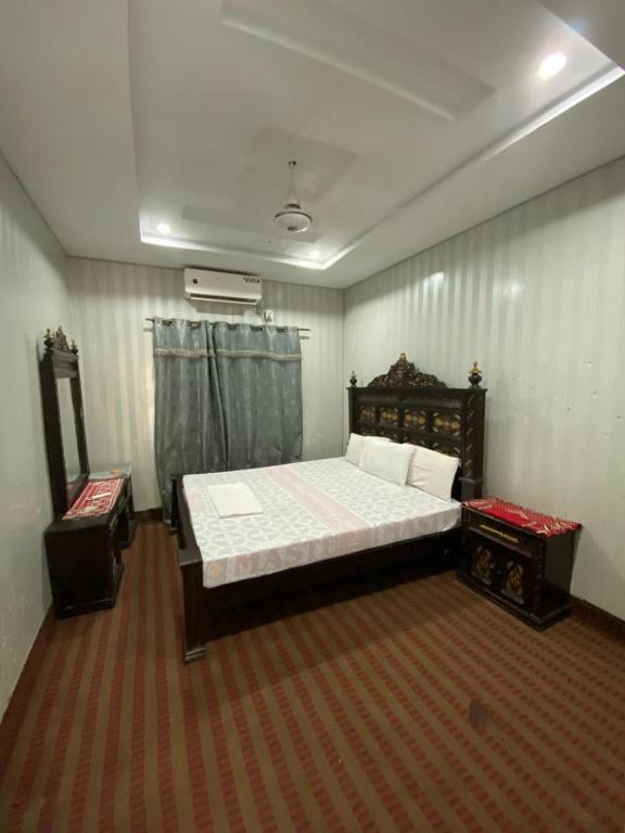 a bedroom with a large bed and a mirror at Getaway lodge Guesthouse in Islamabad