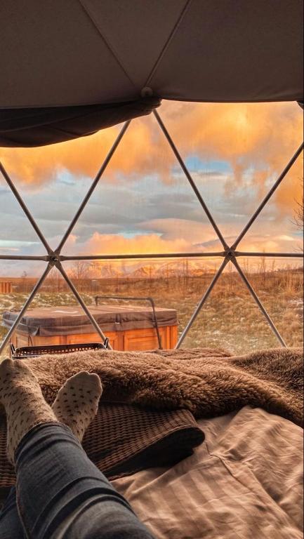 a person laying on a bed looking out of a tent at Rum nore in Disah