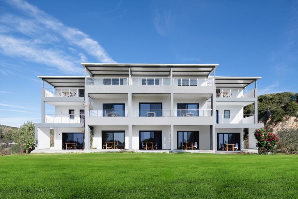 a white house with a green lawn at Villa Miranda Roshi in Toroni