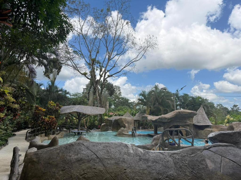 a pool at a resort with people in it at Orquideas Boutique Hotel in Fortuna