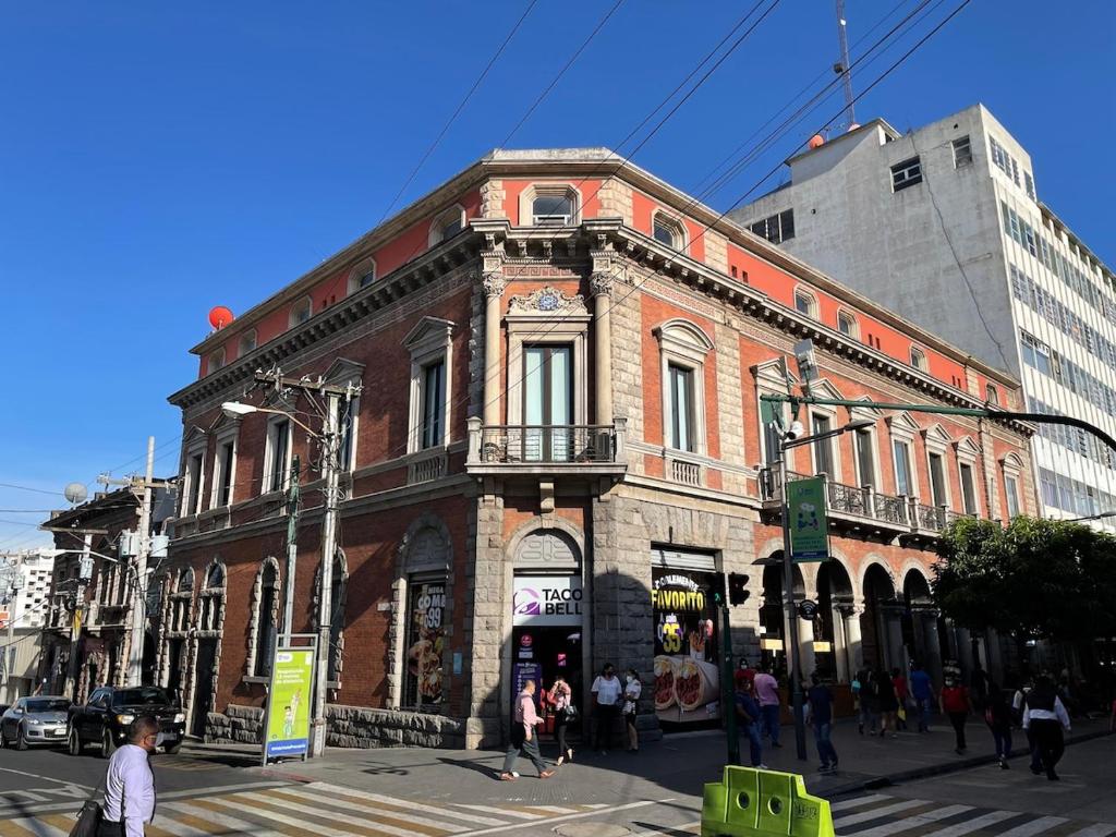 a large brick building on a city street with people standing outside at Apartamento 05 6ta Av Zona 1 Edificio Edwards in Las Victorias