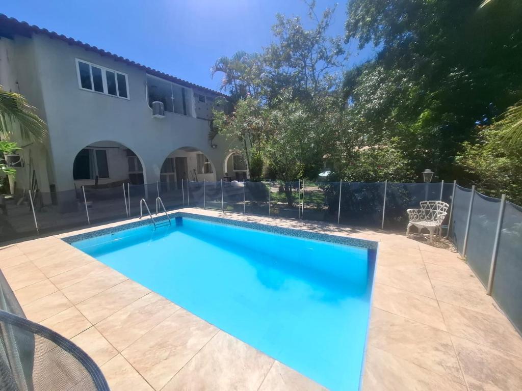 a swimming pool in front of a house at Pousada Colibris da Barra da Tijuca in Rio de Janeiro