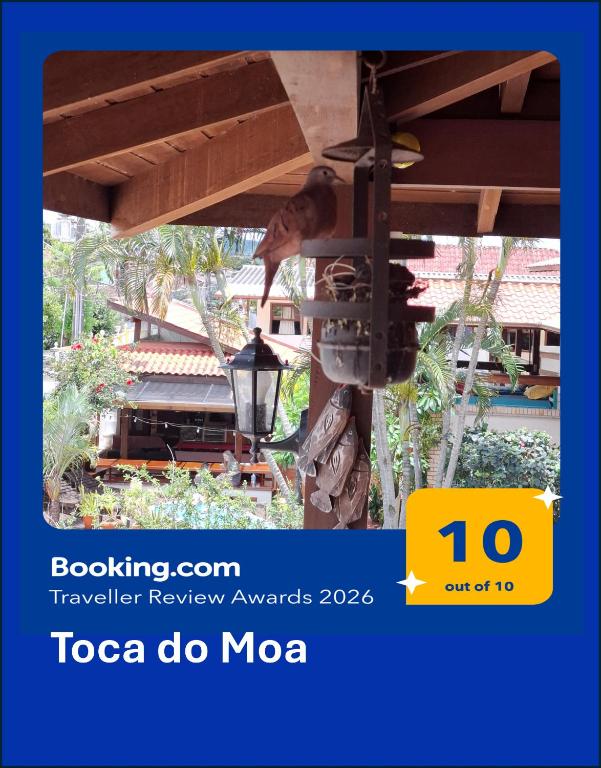 a man is standing under a table with a grill at Toca do Moa in Florianópolis