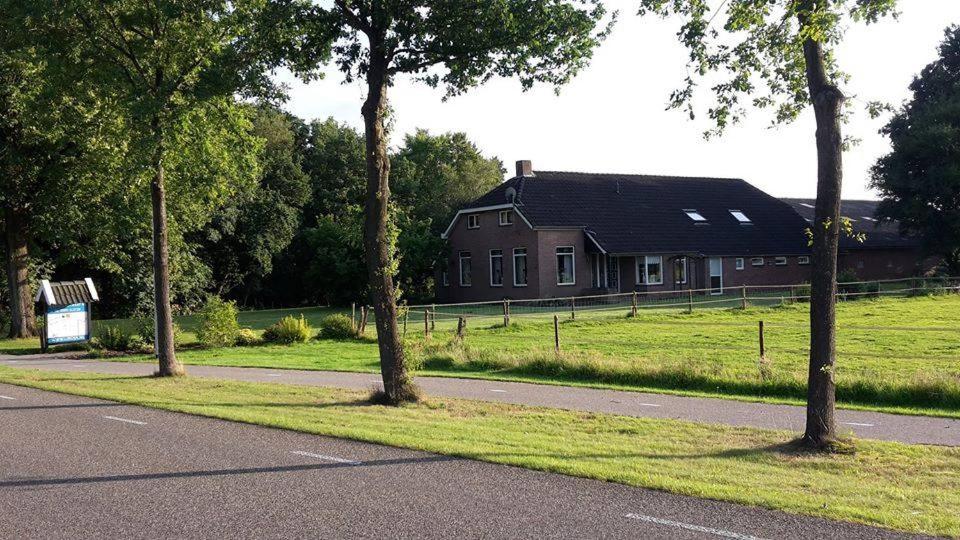 a house on the side of a road with trees at Liroja's Vakantiehuis in Vlagtwedde