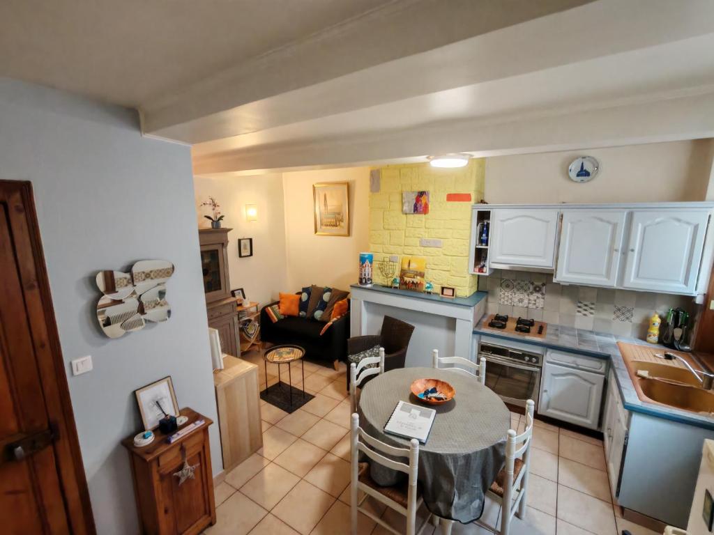 a kitchen and living room with a table and a couch at L'arras Square maison au calme avec deux chambres in Arras
