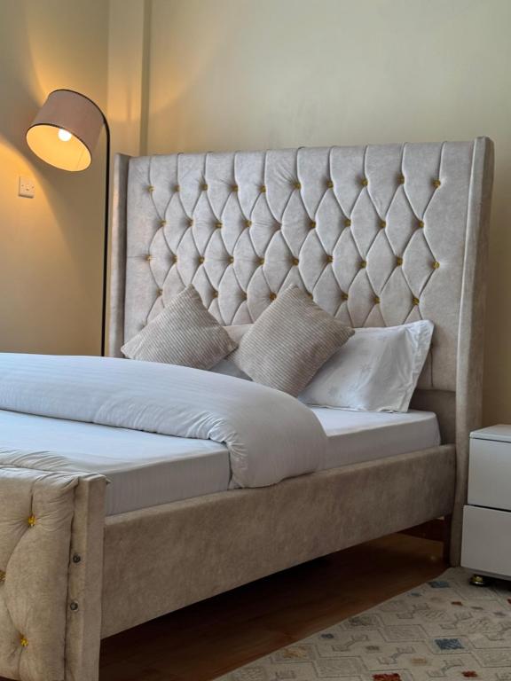 a bed with a tufted headboard in a bedroom at TMT Homes in Nairobi