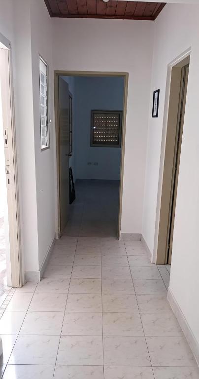 a hallway with white walls and a tile floor at DeptoSarmiento in Paso de los Libres
