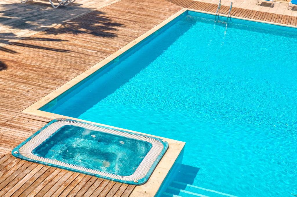 an empty swimming pool on a wooden deck at Apartamento Can Rupit Playa Santandria con jardin y piscina in Son Carrio