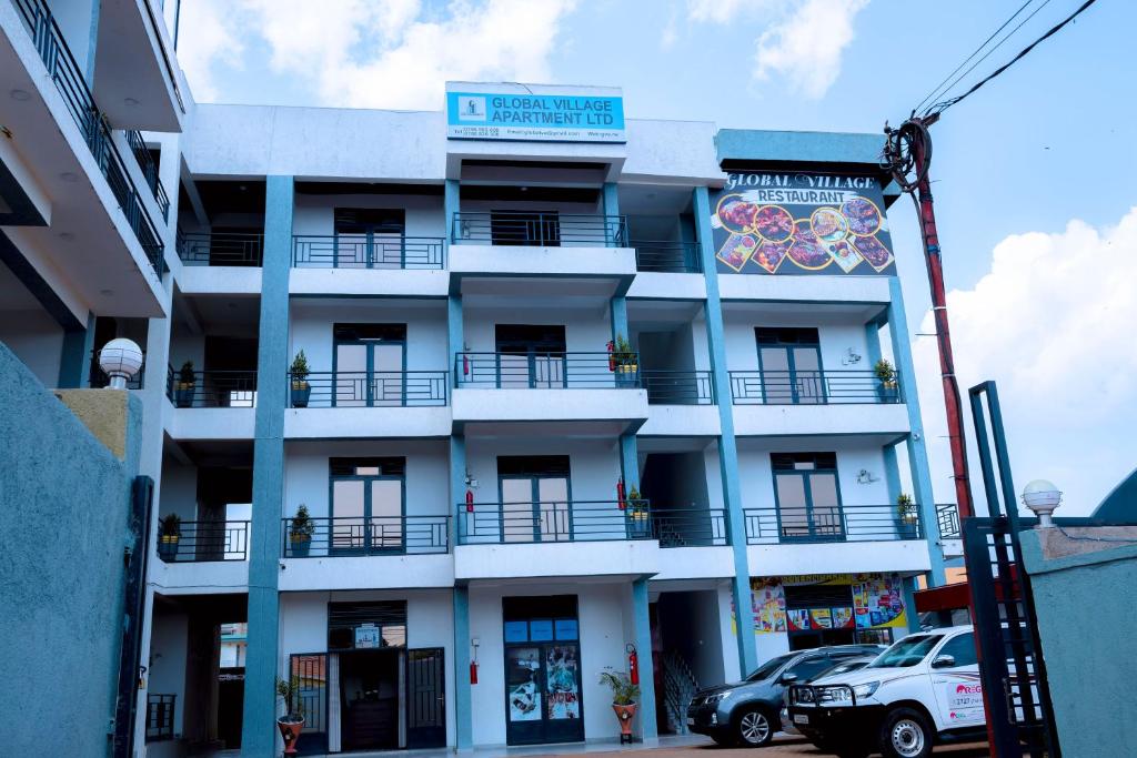 a white building with a sign on it at Global Village Apartment in Kigali