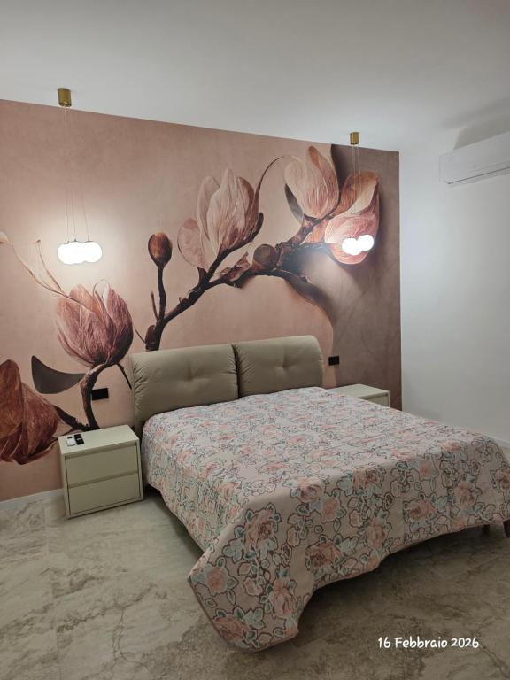 a bedroom with a bed with a flower mural on the wall at B&B Domus morfeo Caserta in Caserta