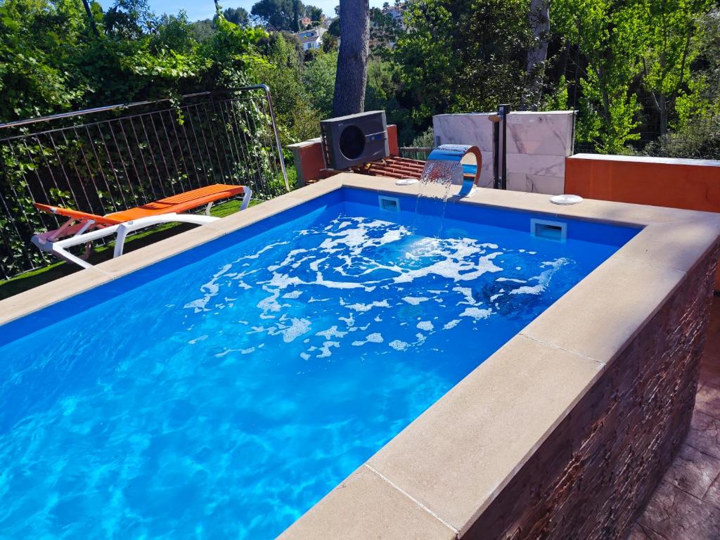 a swimming pool with a table and chairs in a backyard at Relax House Barcelone in Sant Esteve Sesrovires