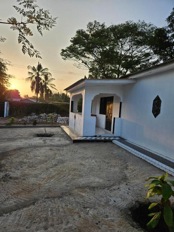a small white building with a sunset in the background at Malindi Jerere BnB in Malindi