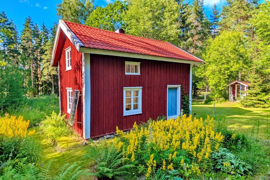 a red shed with a red roof in a field at "Björkhorva" in Vimmerby