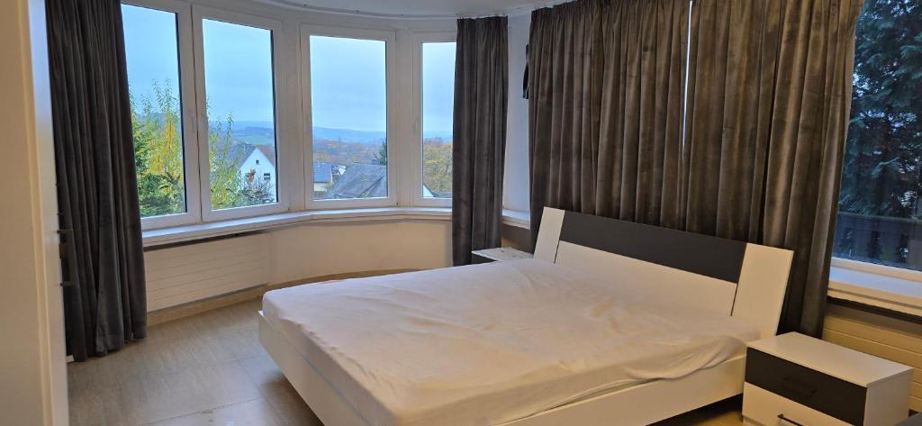a bedroom with a bed in a room with windows at Luxury View in Westerburg