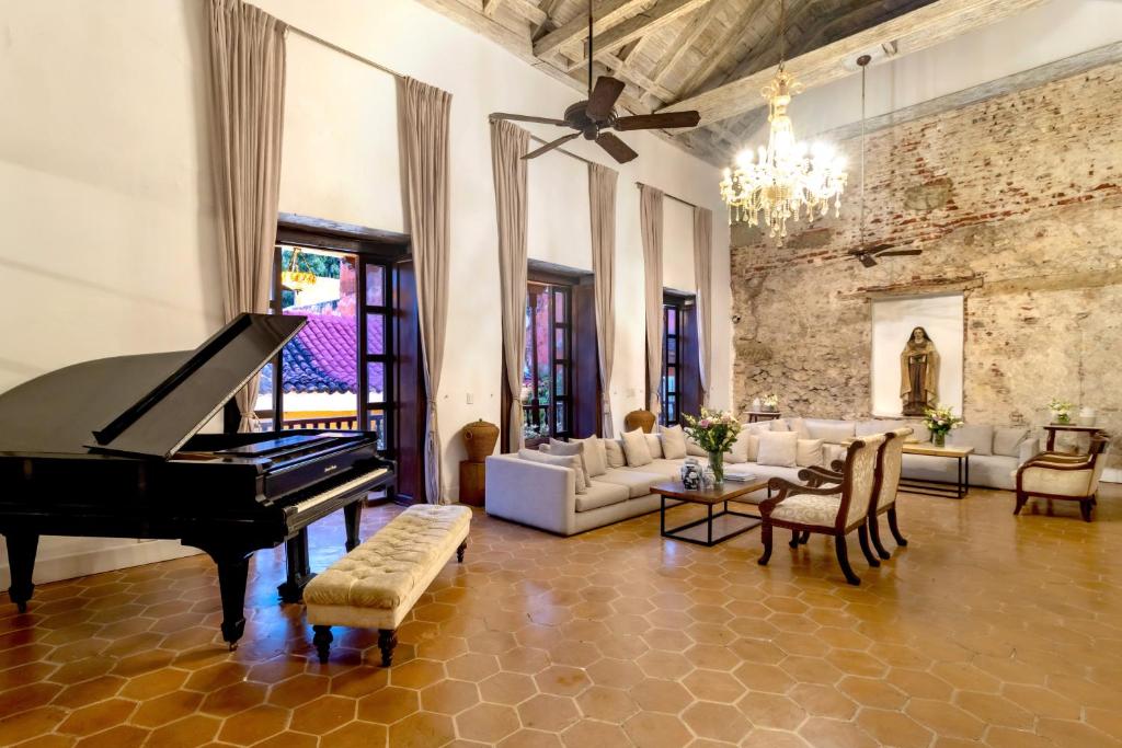 a living room with a piano and a couch at El Marques Hotel Boutique By GEH Suites in Cartagena de Indias