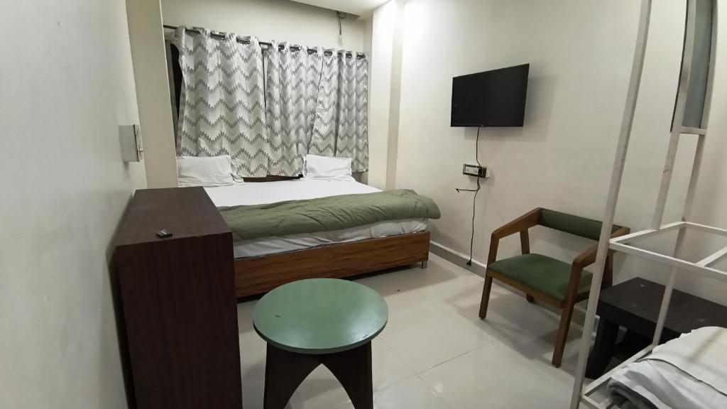 a small bedroom with a bed and a chair at Hotel flexistays central dhantoli in Dhantoli