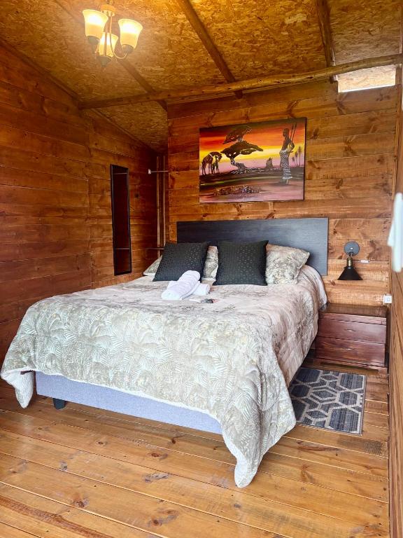 a bedroom with a bed in a wooden cabin at Hotel Cerro Fuerte breakfast & eventos in Sopó