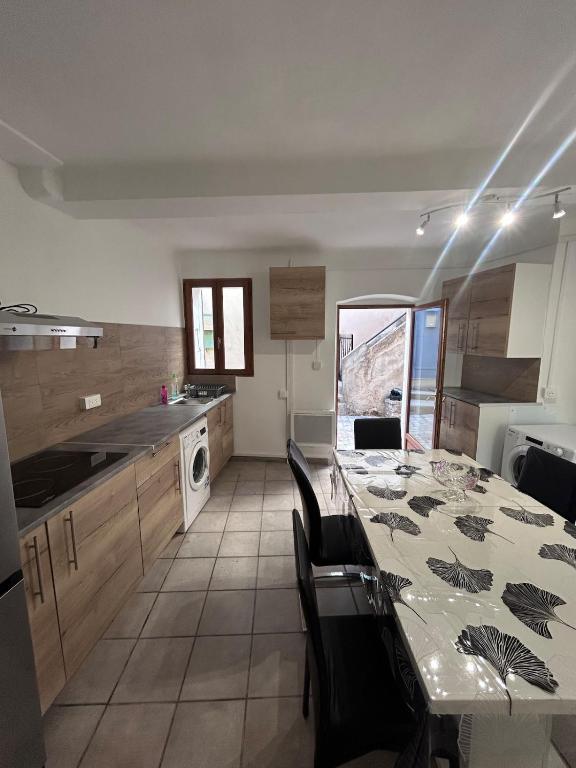 a kitchen with a table with chairs and a tableasteryasteryasteryasteryasteryastery at Le cabanon in Puyloubier