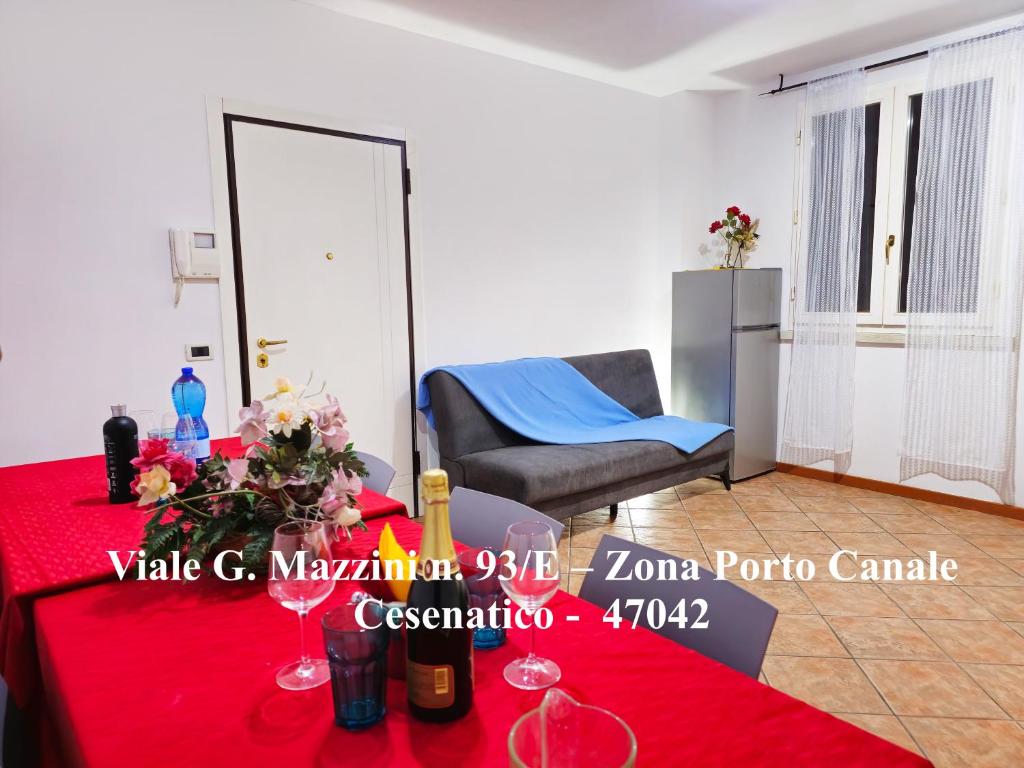 a room with a table with a red table cloth at Appartamenti Cangini in Cesenatico