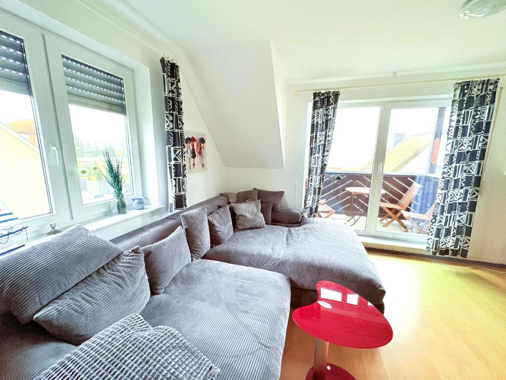 a living room with a couch and a red stool at Fewo Weitblick - helle Wohnung, 2 SZ, Wasserblick in Breege