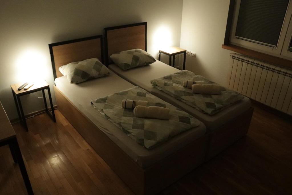 a bedroom with a large bed with two pillows at Apartments Peka in Dušanovac (historical)