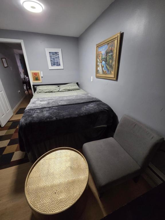 a bedroom with a bed and a table and a chair at Queen Private room with private bathroom in Irvington