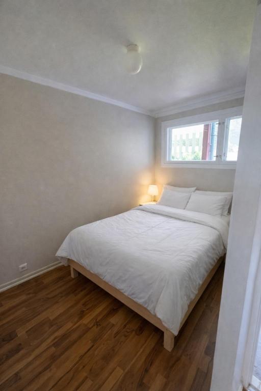 a bedroom with a white bed with a window at Eide Apartments Odda in Odda