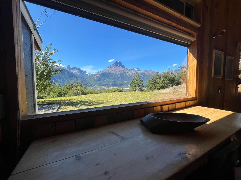 a window with a bowl on a wooden table with a view at Ventana al Castillo in Villa Cerro Castillo