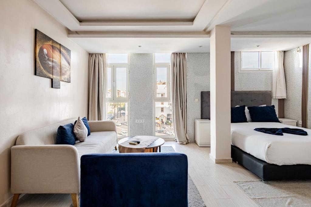 a hotel room with a bed and a couch at Moderne studio au coeur de rabat in Rabat