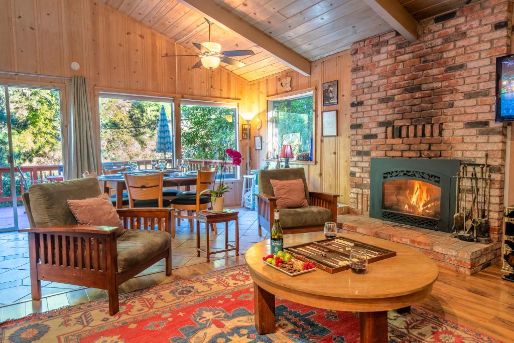 a living room with a fireplace and a table at Aunt Ginnys River View in Monte Rio