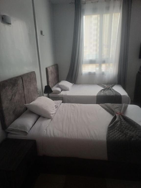 a hotel room with two beds and a window at Capital Hotel in Downtown in Cairo