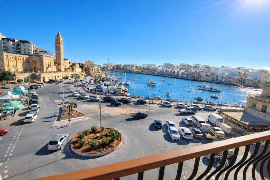 a view of a city with cars parked in a parking lot at Seafront 4-Bedroom Townhouse with Panoramic Views in Iż-Żlielaq