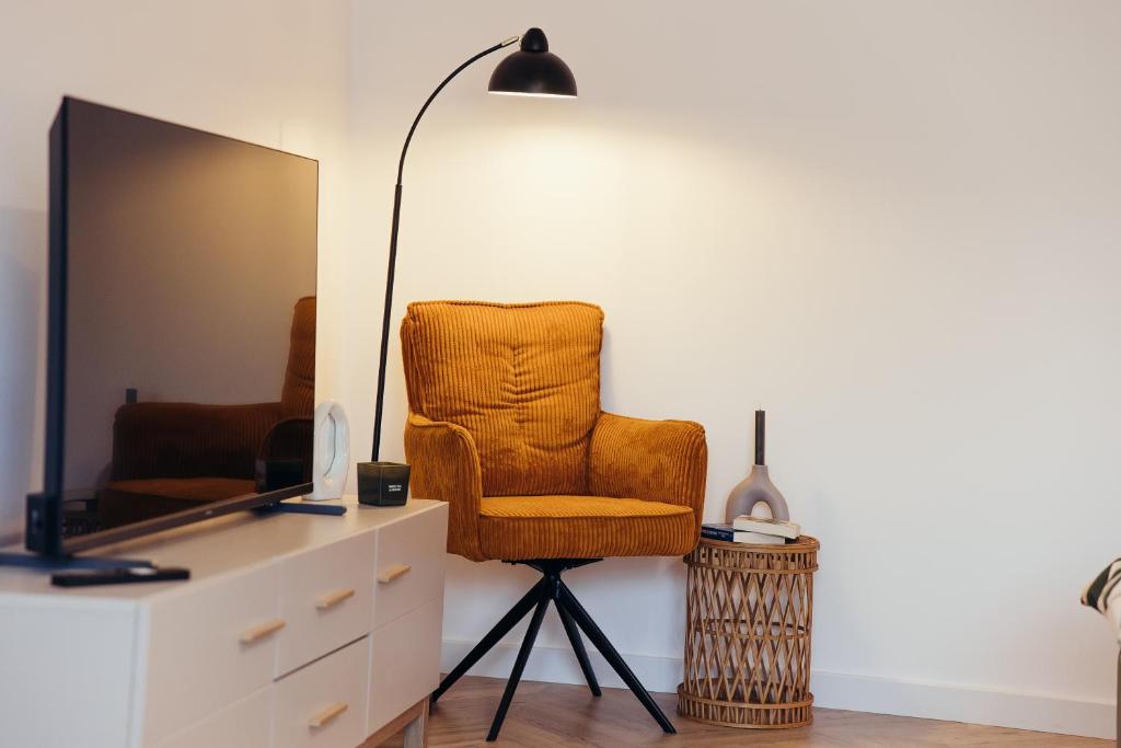 a room with a chair and a dresser and a lamp at IUGAs RESIDENCE in Sighetu Marmaţiei