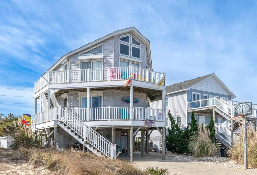 a large house with white balconies on a beach at Key to Paradise - Kitty Hawk MP 4, Pool, Hot Tub, Excellent Ocean View, Easy Beach Access in Kitty Hawk