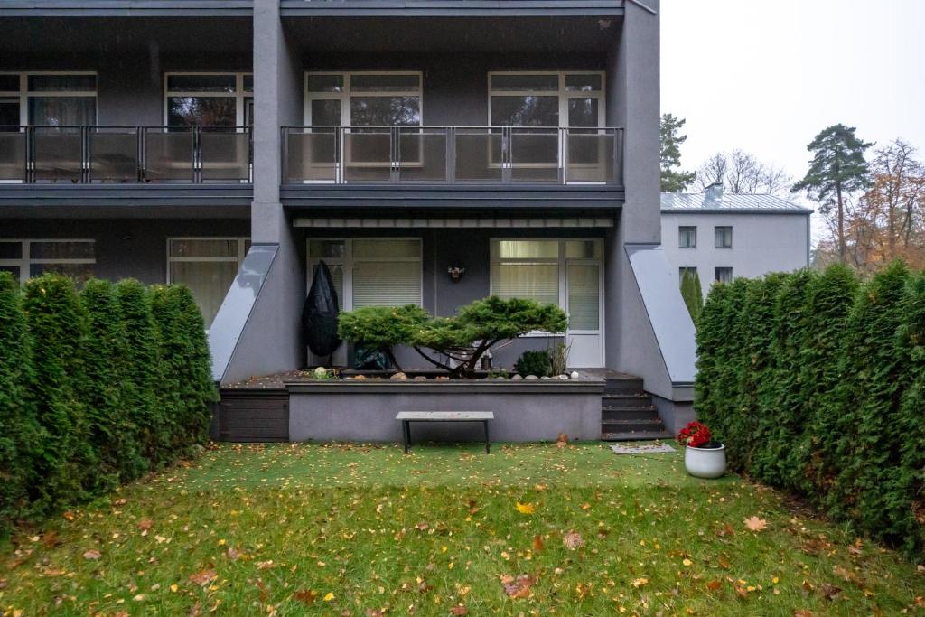 a house with a bench in the front yard at Beachside Studio with Private Garden & Terrace 100m to the beach in Jūrmala