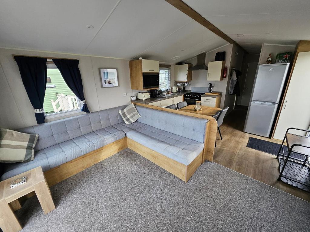 a living room with a couch and a kitchen at Rendezvous at Ocean Edge in Heysham