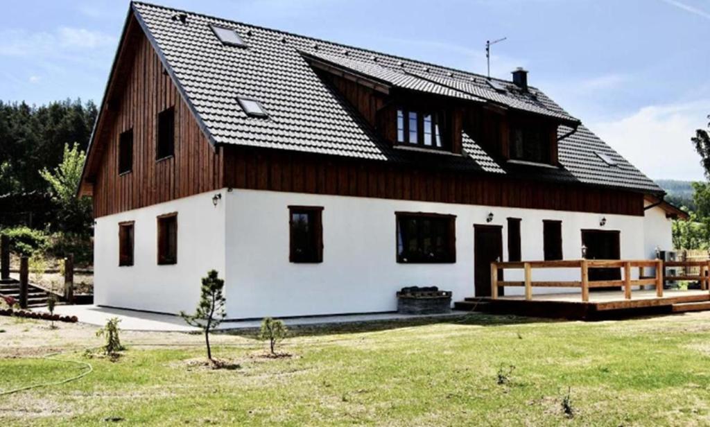 a large white house with a gambrel roof at Penzion U Anděla in Zdíkov