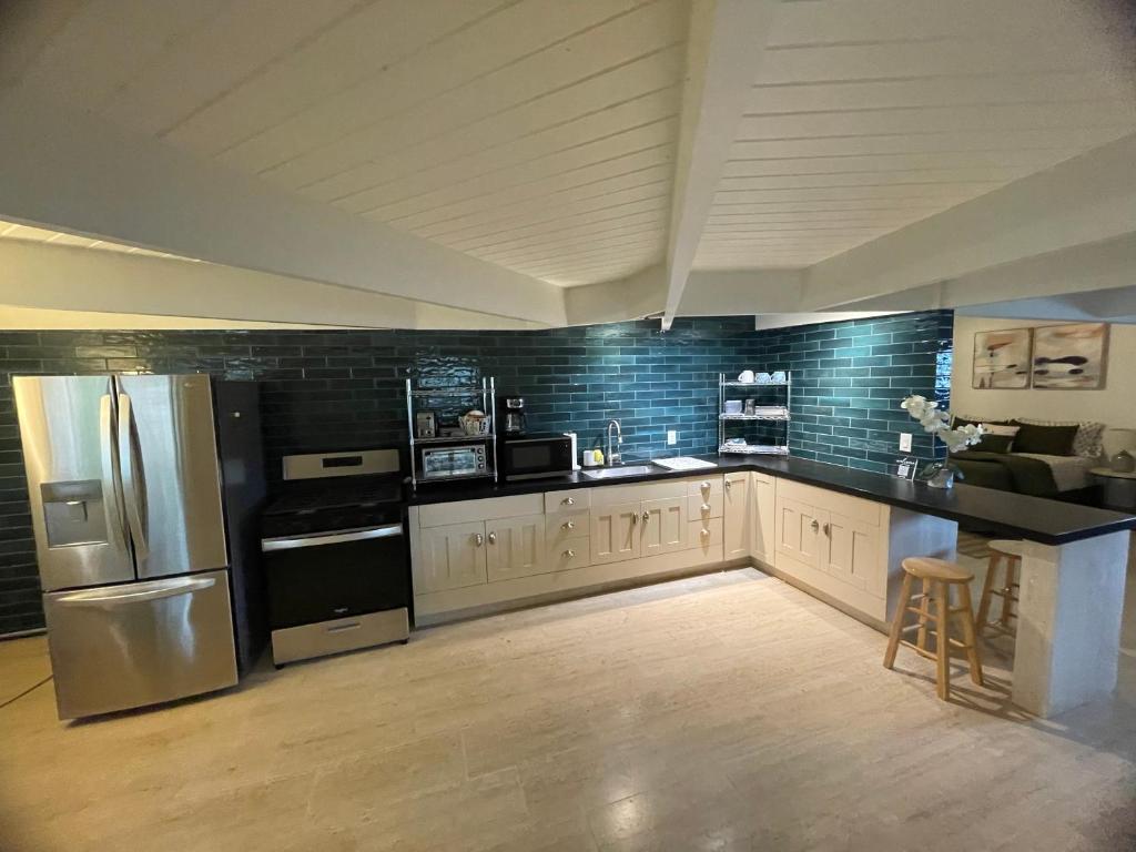 a large kitchen with a refrigerator and a counter at Hawaii Private Studio in Holualoa