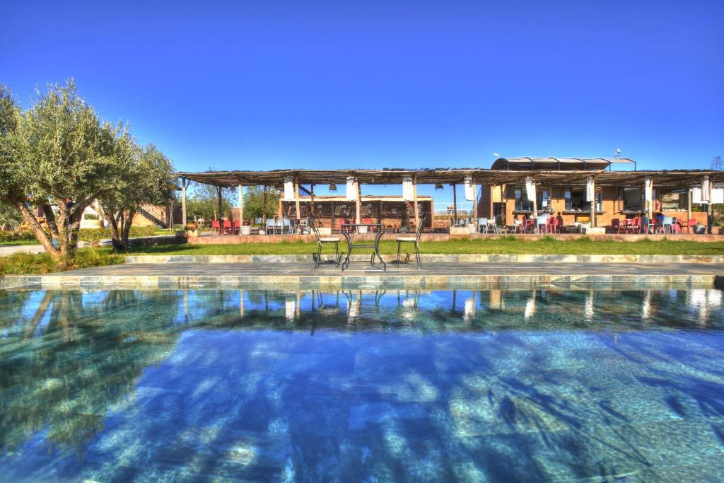 a large pool of water with a building in the background at The Ranch Camp in El Karia