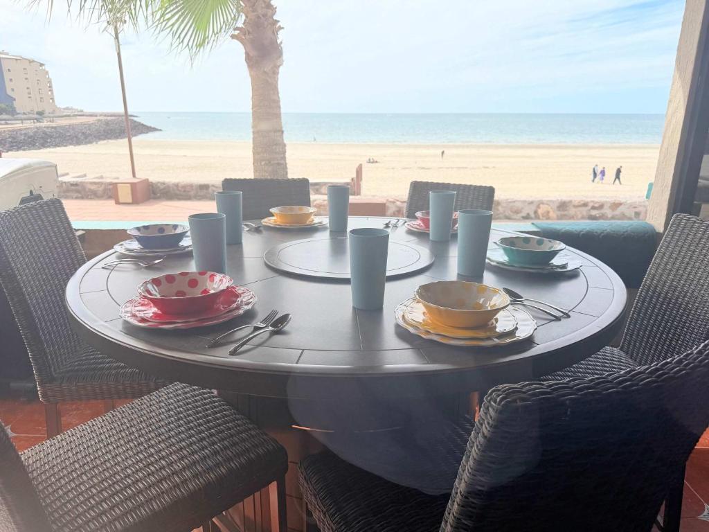 a table with plates of food on the beach at Las Gaviotas 2BR 2BA Ocean View 1st FL- 413 in Puerto Peñasco