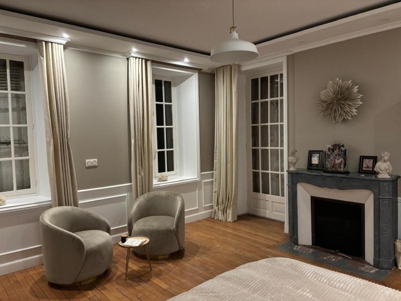 a living room with two chairs and a fireplace at Chambre dans demeure de caractère in Missy-sur-Aisne