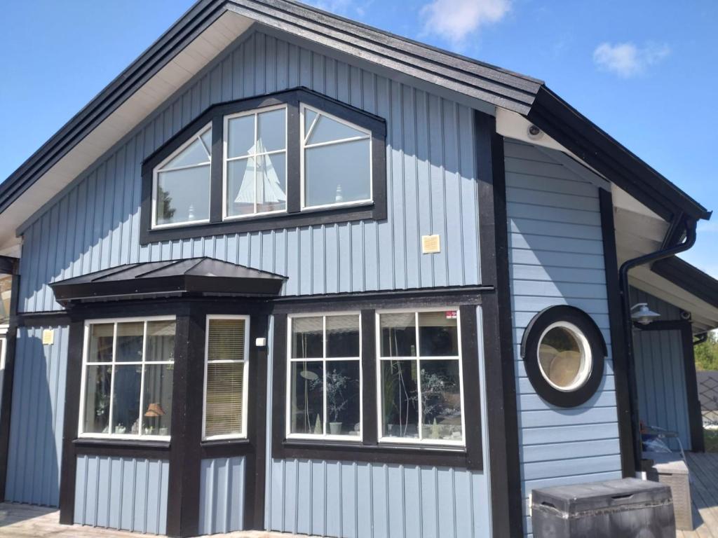 a house with blue siding and windows at Villa i sommaridyll 4 sovrum in Strömstad