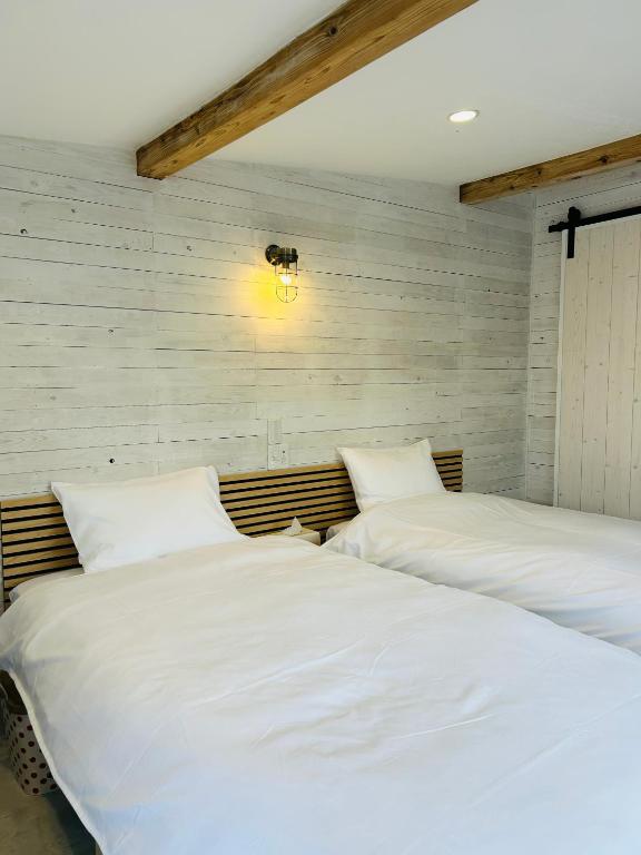 two beds sitting next to each other in a bedroom at Private Stay HANARE in Shishikui