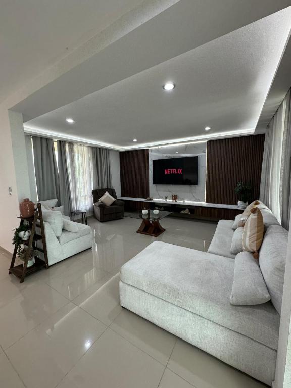 a living room with a couch and a tv at Casa Altavista in Pachuca de Soto