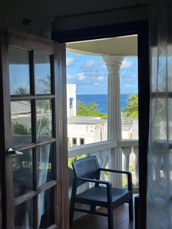 a room with a view of the ocean from a balcony at Villa Azure in Tower Isle