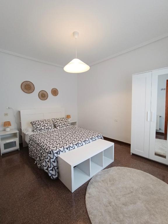 a white bedroom with a bed and a white table at Entre Mar y Montañas in Vall de Uxó