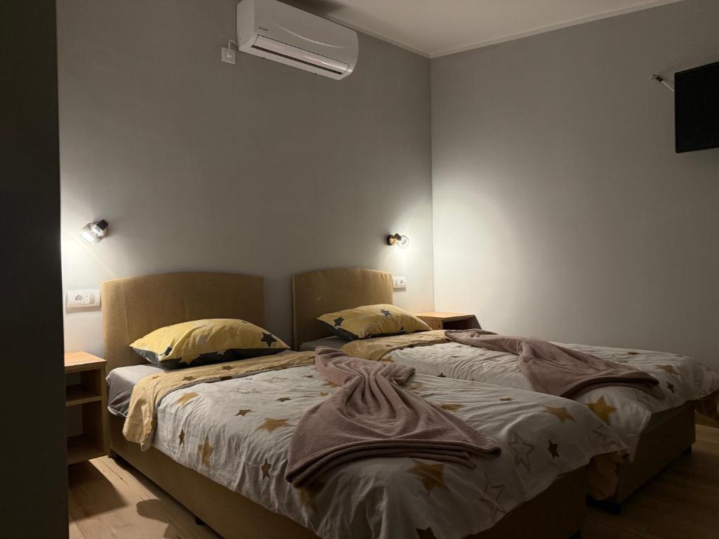 two beds sitting next to each other in a bedroom at Duplex Oasis Rooms in Ada